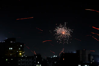 Festive fireworks bursting in the night sky over a lively city celebration