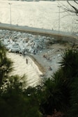 A small group of travelers quietly observing a coastal tide pool.