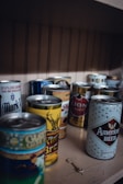 An organized shelf showcasing different beer can designs.