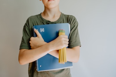 A happy student holding a notebook with good grades.