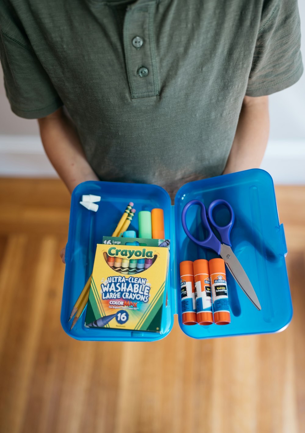 a person sits at a table with a box of scissors and a bag