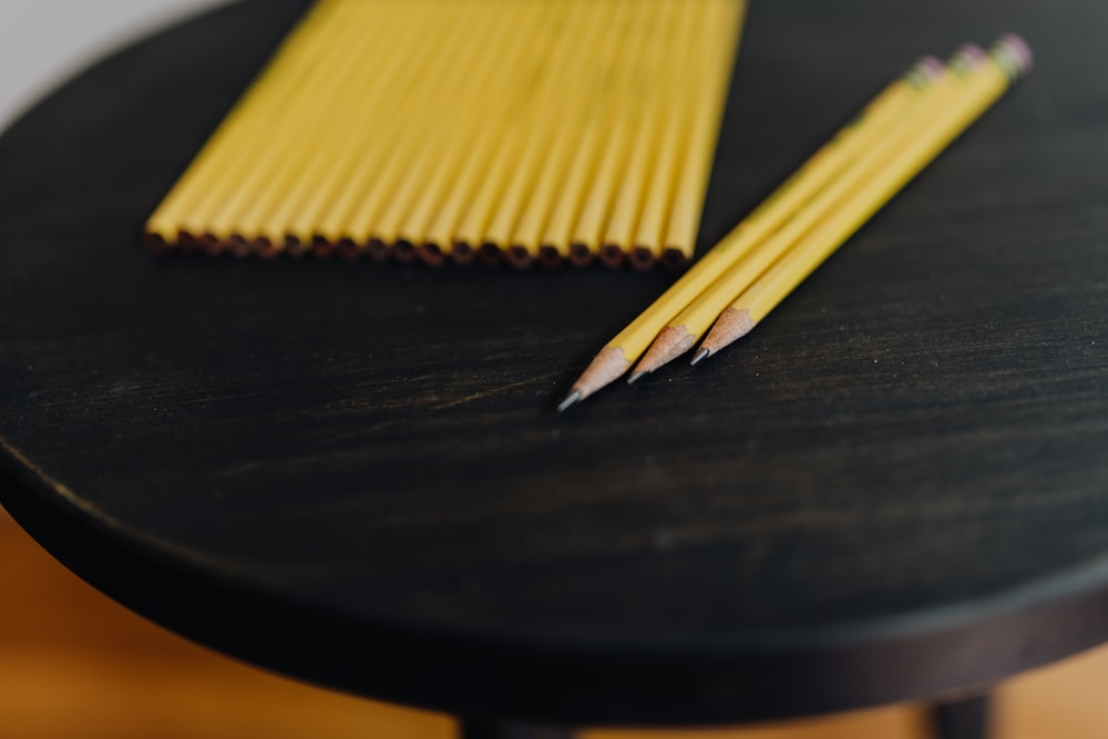 a few pencils on a black surface