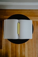 Open notebook with handwritten lyrics and a pencil on a wooden table.