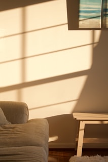 A cozy living room wall adorned with a woven seagrass basket and a canvas abstract print, sunlight casting gentle shadows.