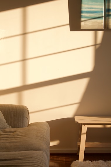 A cozy living room wall adorned with a woven seagrass basket and a canvas abstract print, sunlight casting gentle shadows.