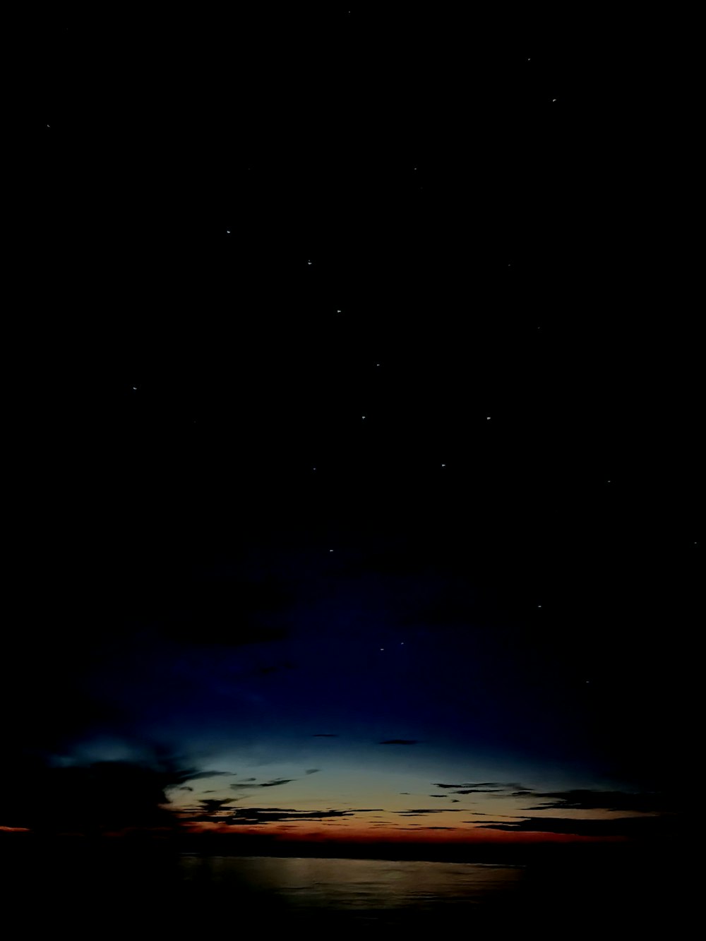 a body of water with a dark sky above it