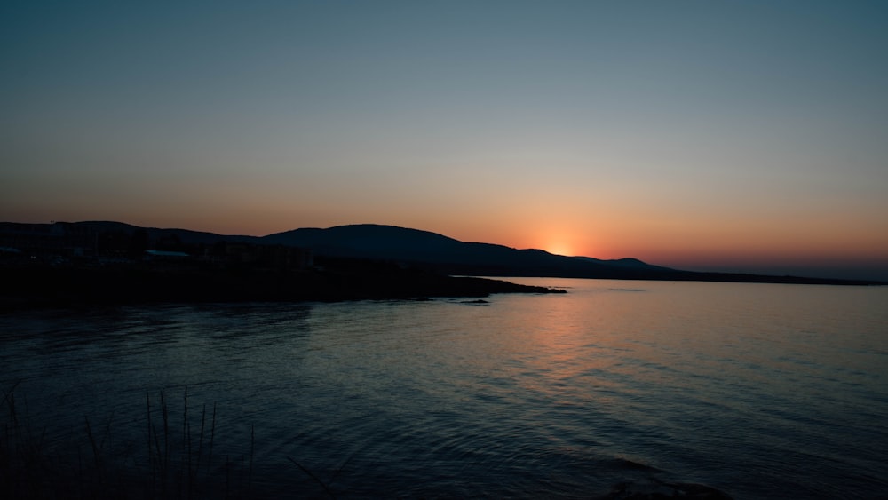 a body of water with hills in the background