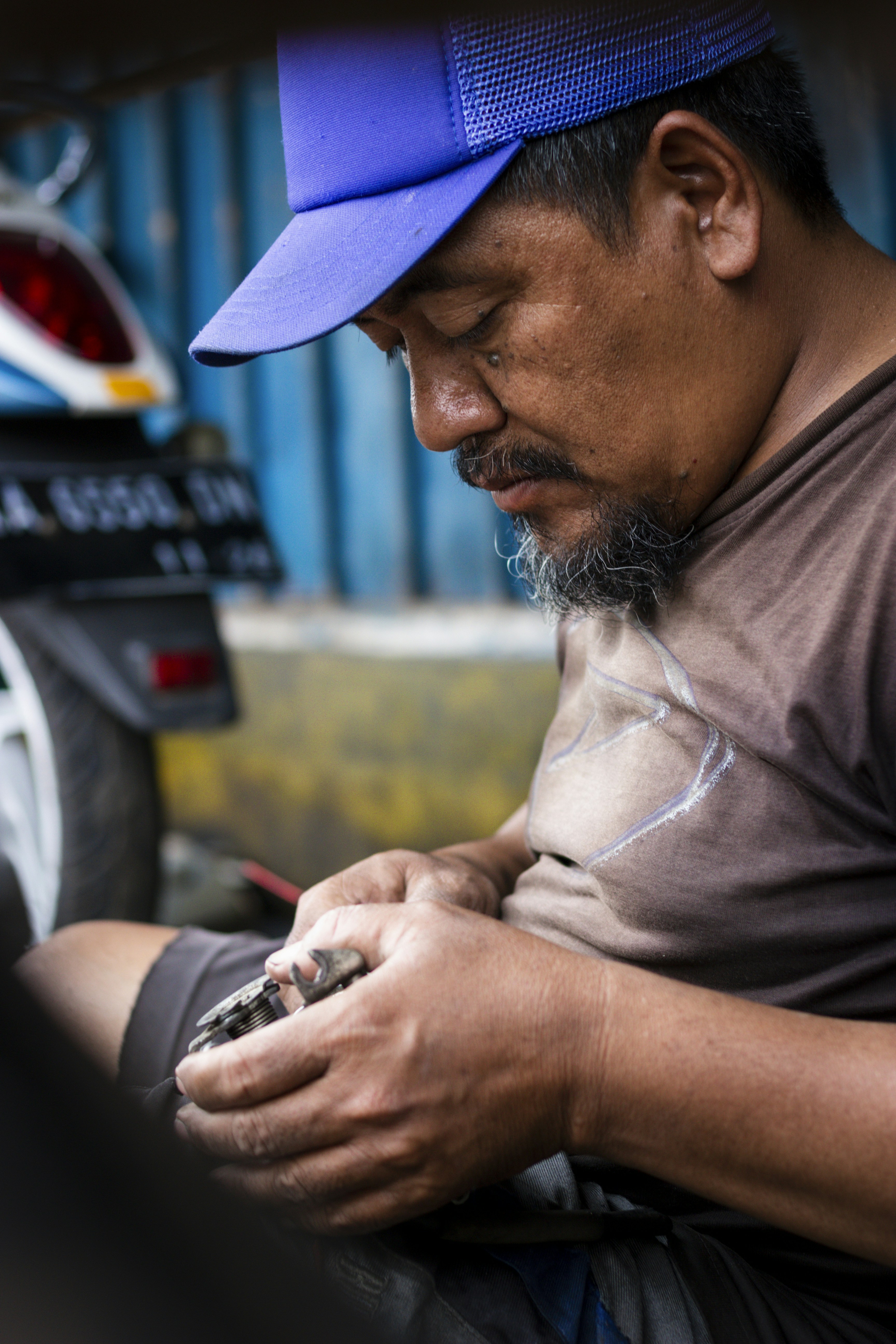 Pria bertopi biru mengerjakan benda kecil