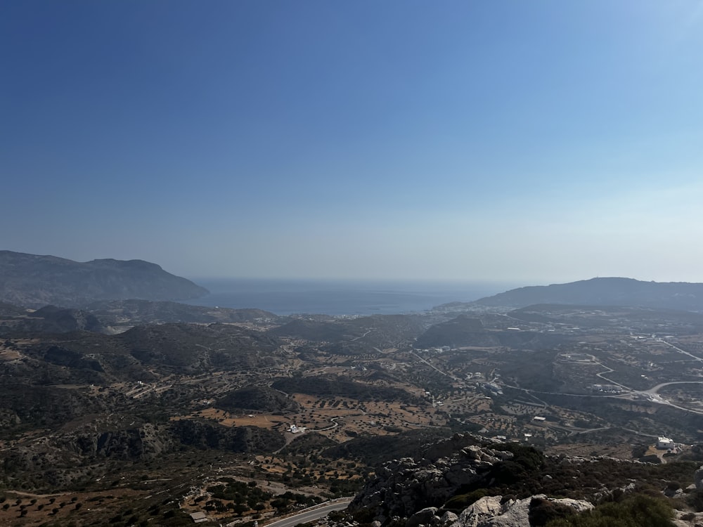 a landscape with hills and a body of water in the distance