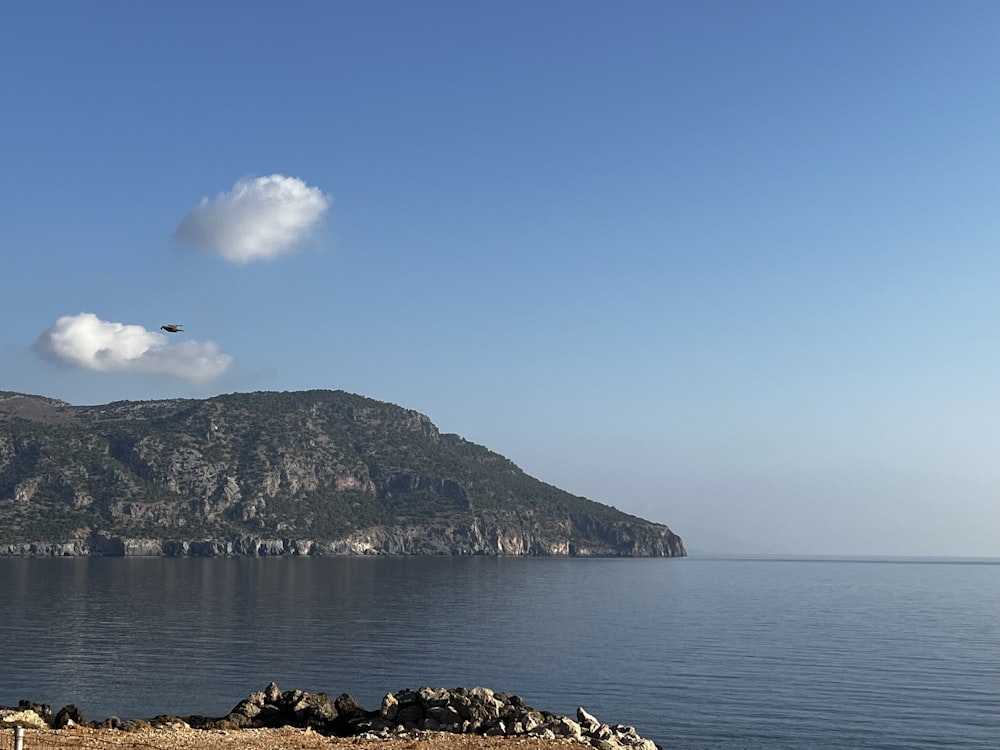 a large island with a body of water and a large mountain in the background