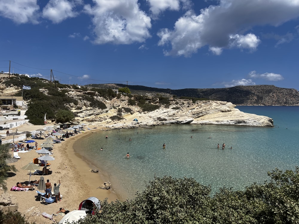 a beach with people and umbrellas