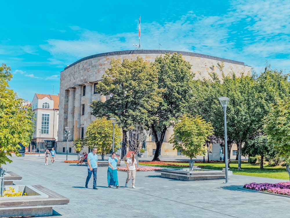 a group of people walking around a large building