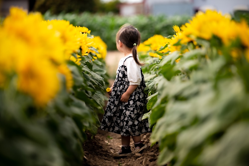 Ein kleines Mädchen steht in einem Garten