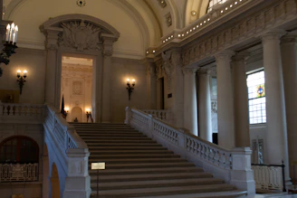 An elegant marble foyer with gold accents and soft neutral tones, inviting guests into a prestigious home.