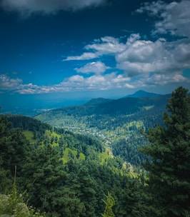 A scenic view of Bhim Band surrounded by lush greenery under a clear blue sky.