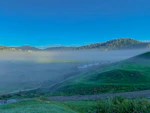 A serene Andean landscape with morning mist over green valleys and ancient trees.