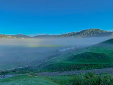 A serene Andean landscape with morning mist over green valleys and ancient trees.