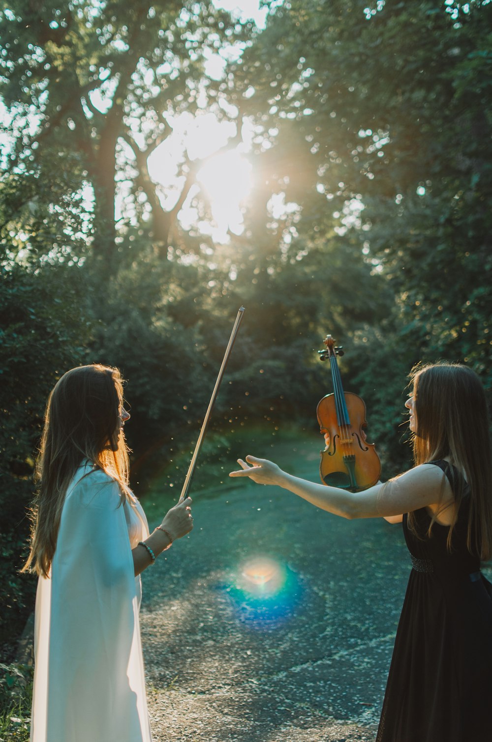 a person playing a violin next to a person in a white dress