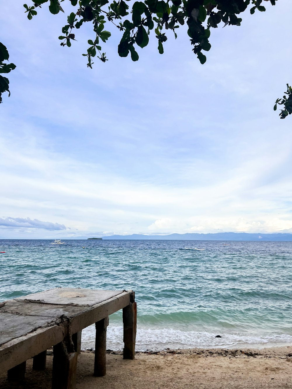 a beach with a wood bench