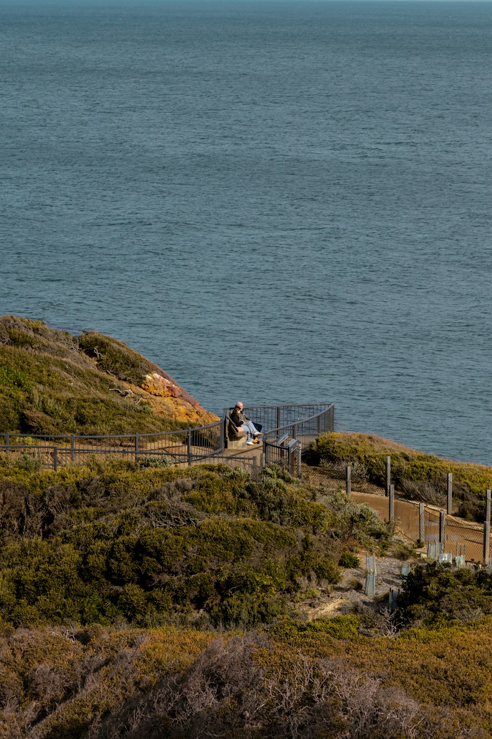 a couple sitting on a bench overlooking a body of water