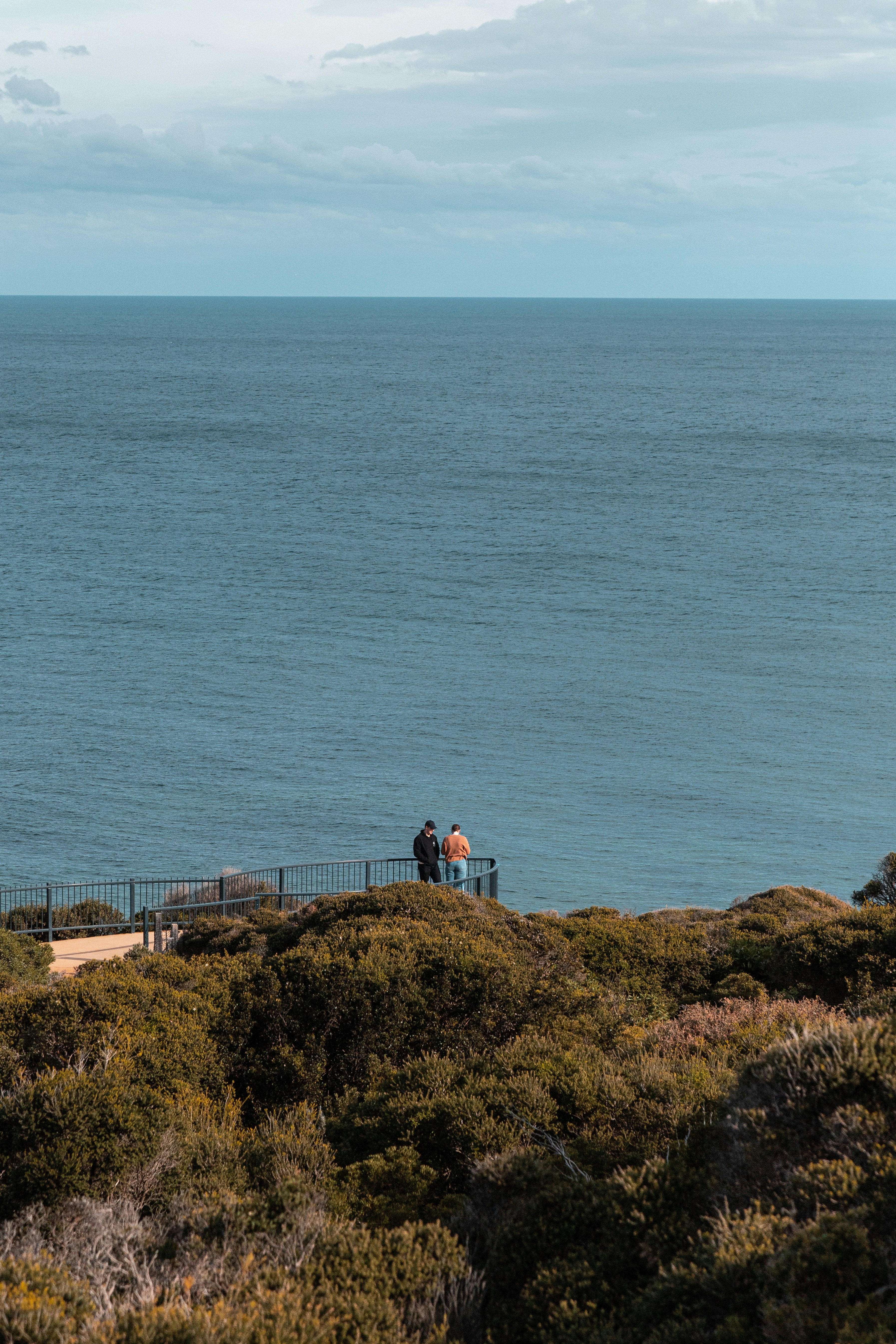 Ein paar Leute, die auf einer Brücke über ein Gewässer stehen