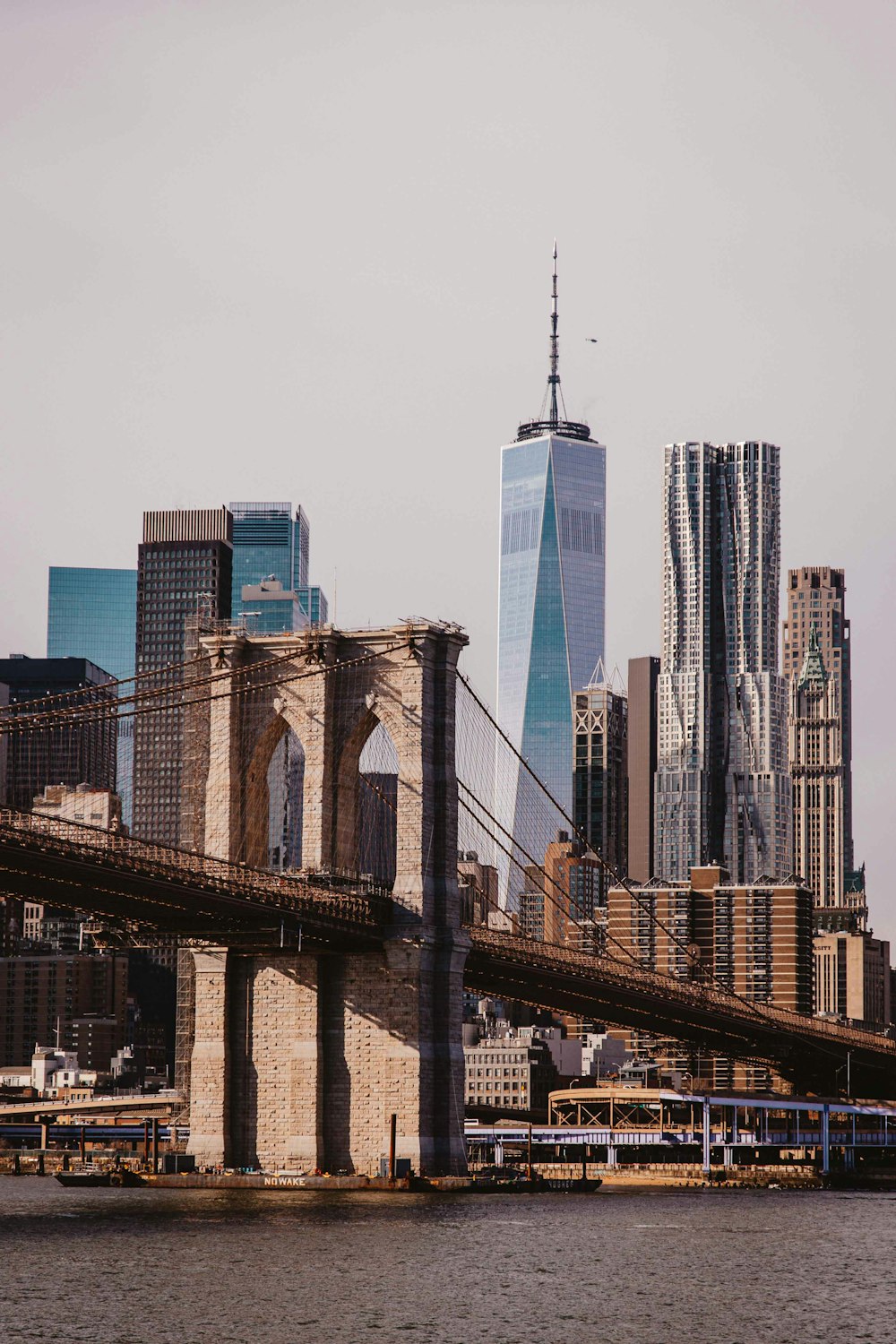 a bridge over a river with tall buildings in the background