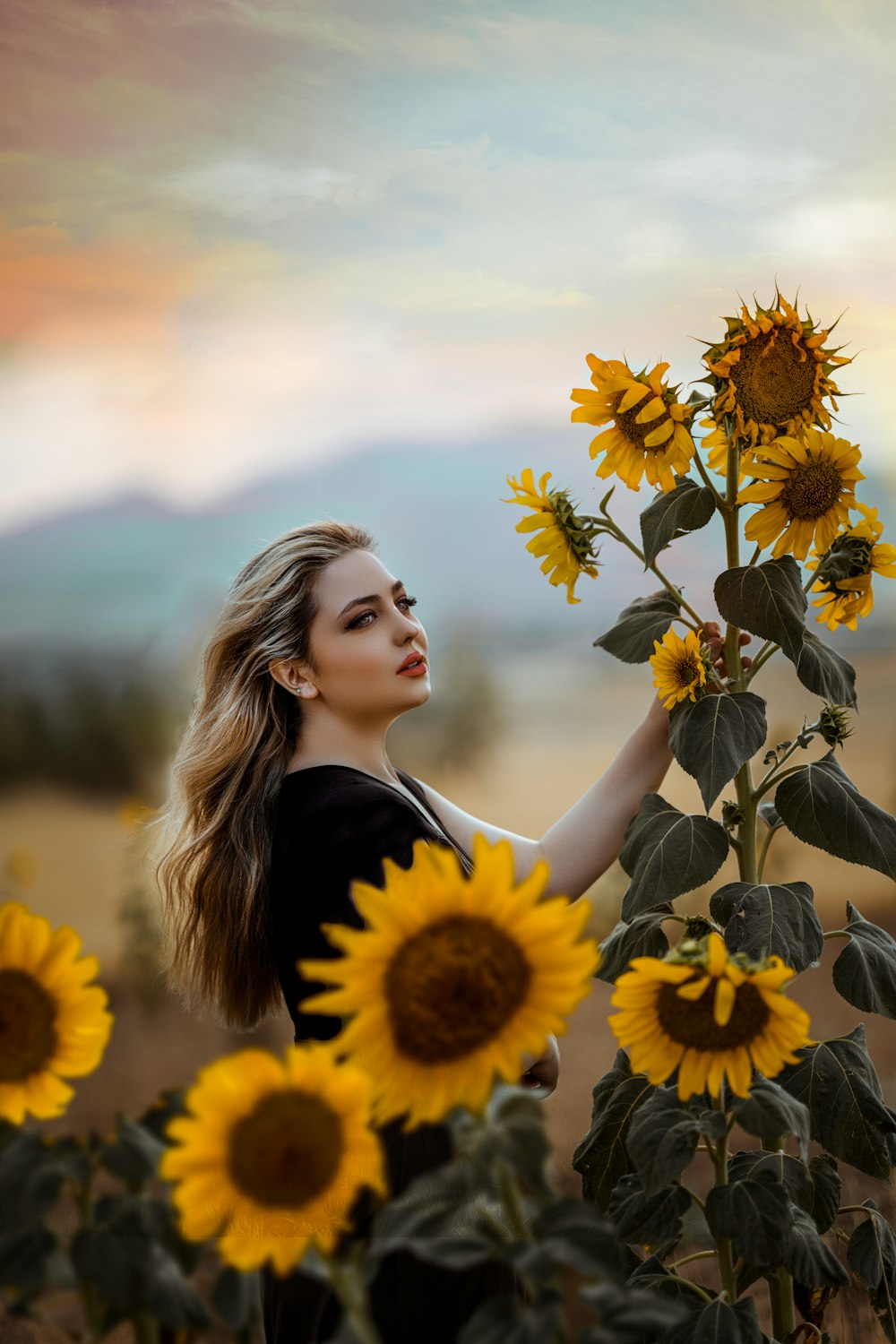a person posing with a field of sunflowers