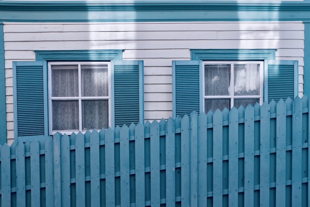 a white fence with blue shutters
