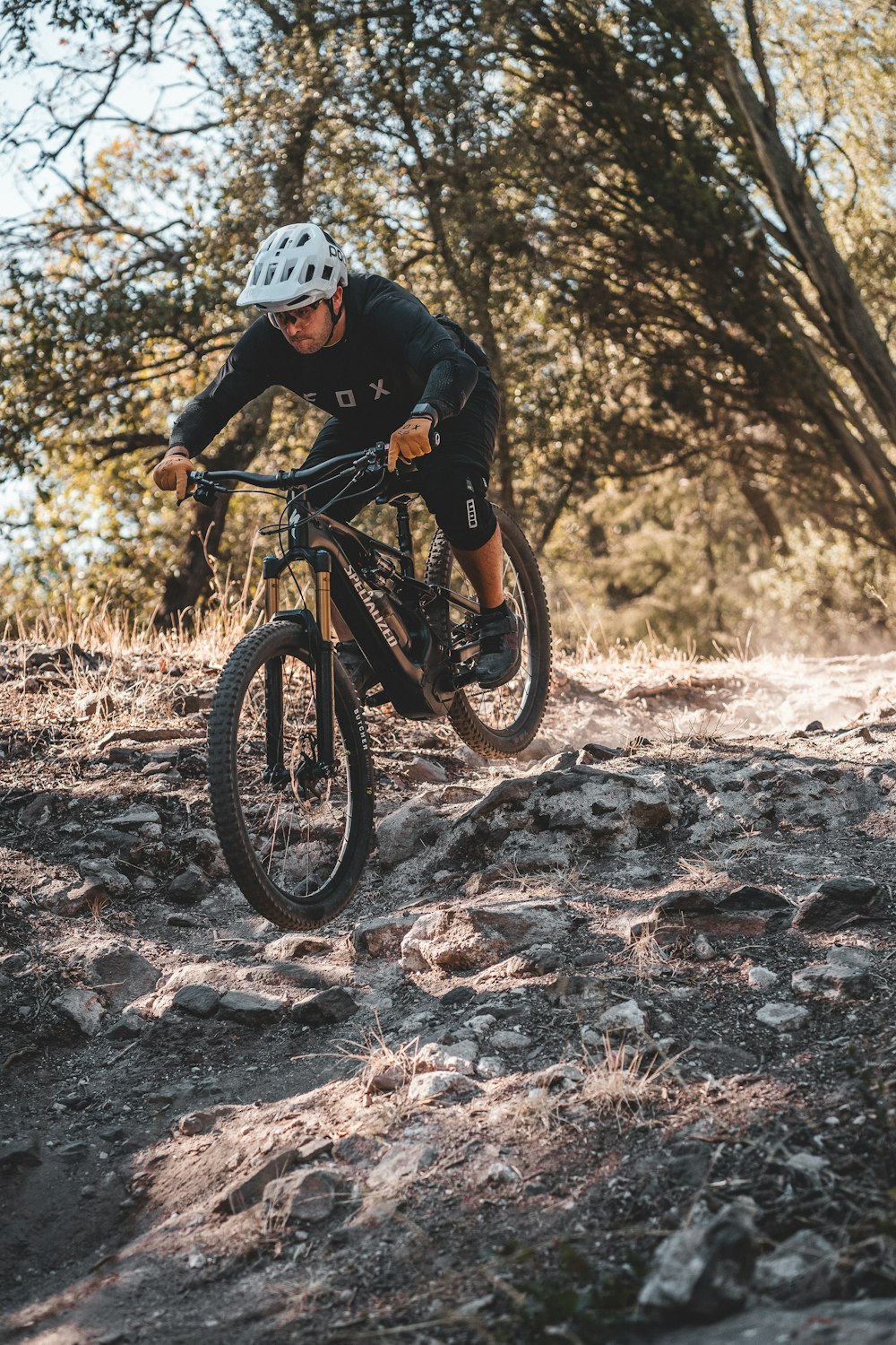 a man riding a bike on a rocky trail