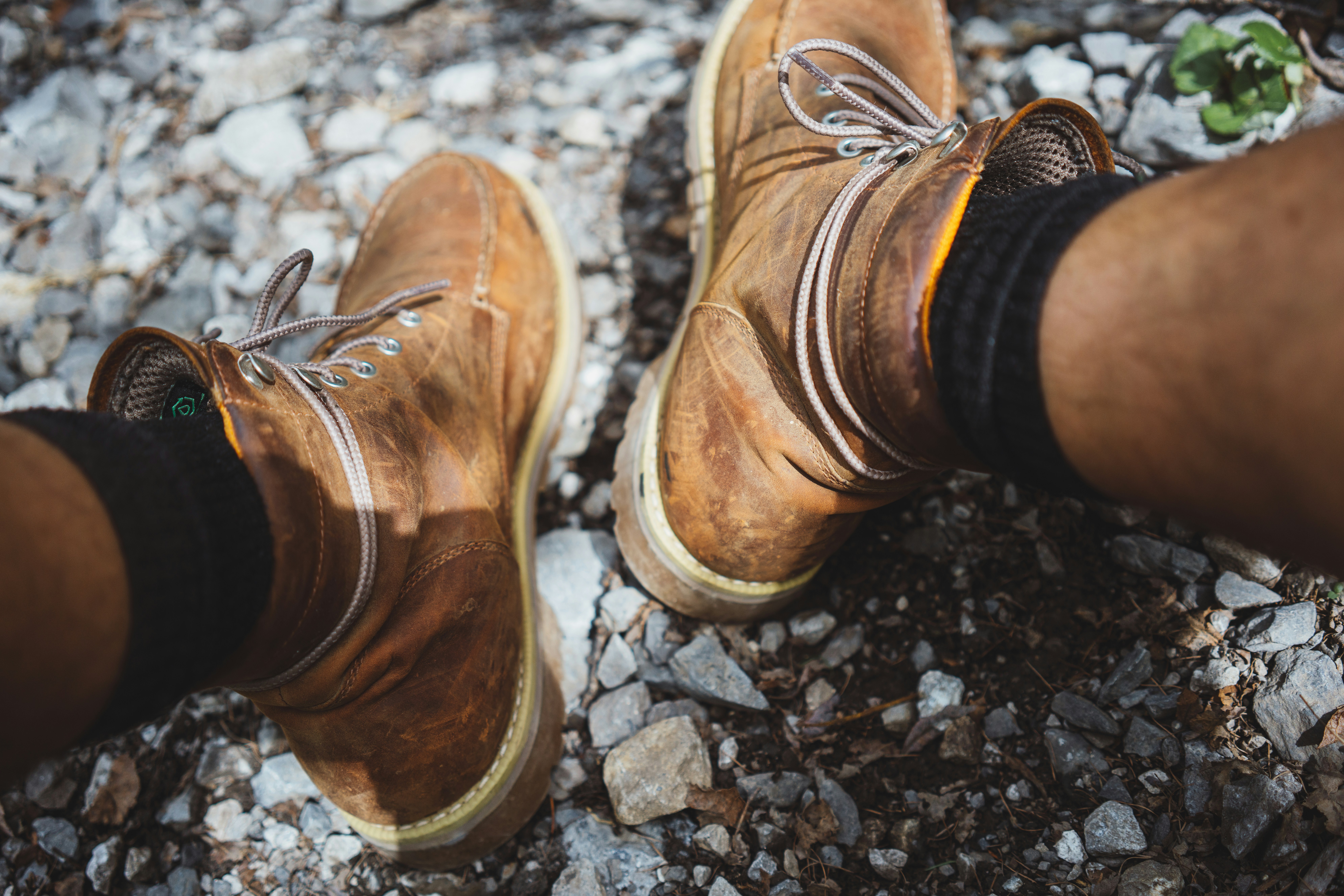 Brown and tan hiking boot on rocky outdoor surface
