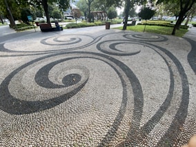 a paved area with trees and grass