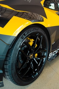 Close-up of a car wheel in motion with yellow accents.