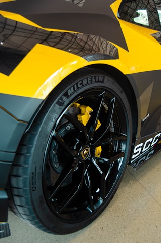 Close-up of a car wheel in motion with yellow accents.