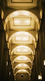 Elegant hallway in a premium hotel, softly lit with gold-toned wall sconces.