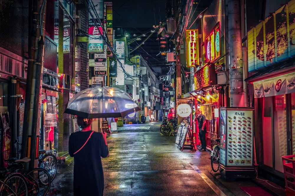 an umbrella is walking down the street in front of a store