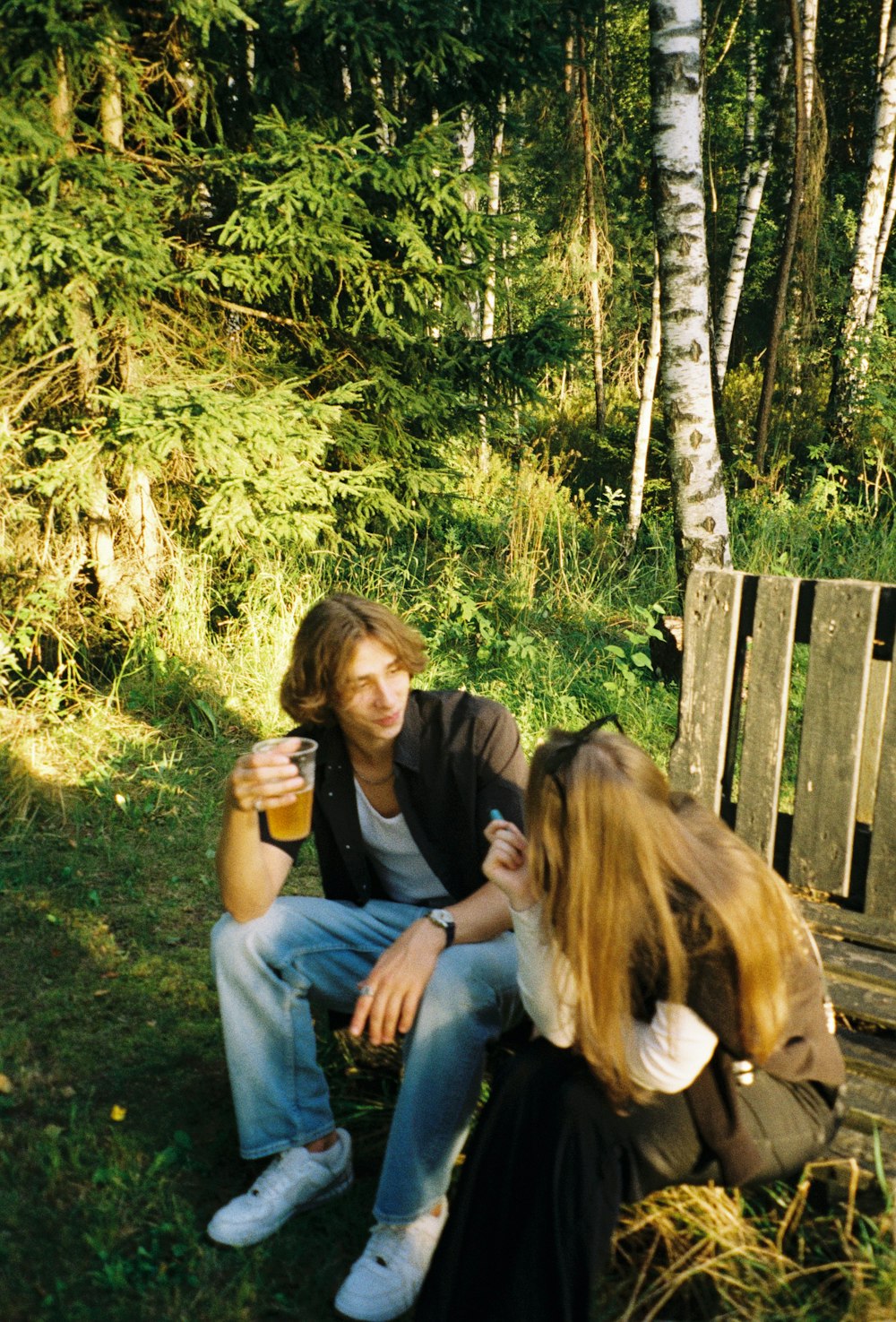 a person sitting next to a girl outside