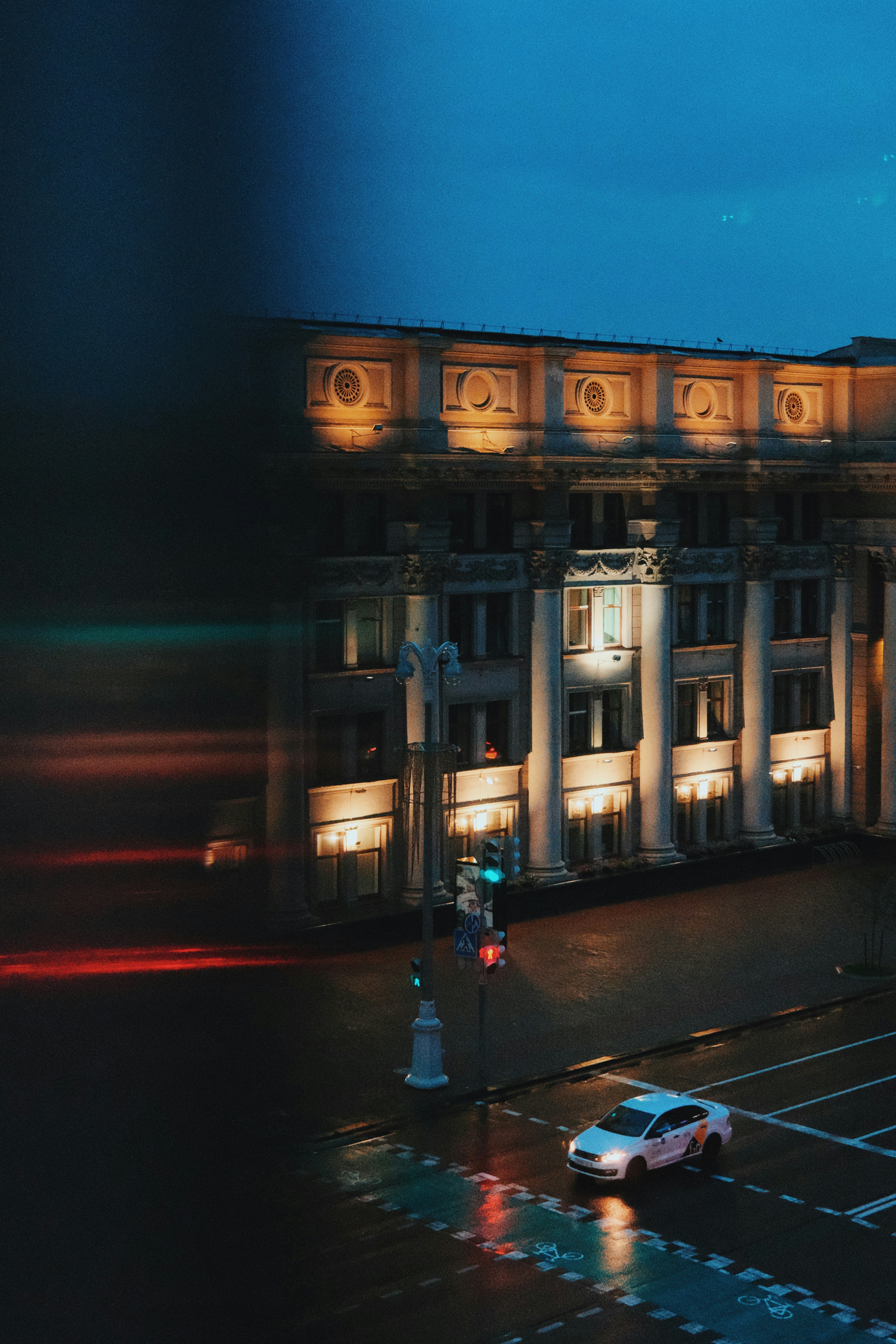 ein Gebäude mit Säulen und einem Parkplatz davor