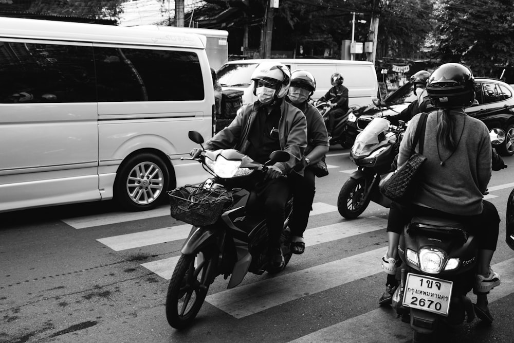 a group of people ride on scooters