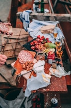 A rustic wooden table with a variety of exotic jerky sticks and a handwritten note beside a vintage pen.