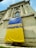 A large building with classical architectural features, including tall columns and decorative stonework. There is a prominent banner draped over the facade, featuring the word 'SOLIDARITATE' and its equivalent in another language, printed in blue on a yellow background.