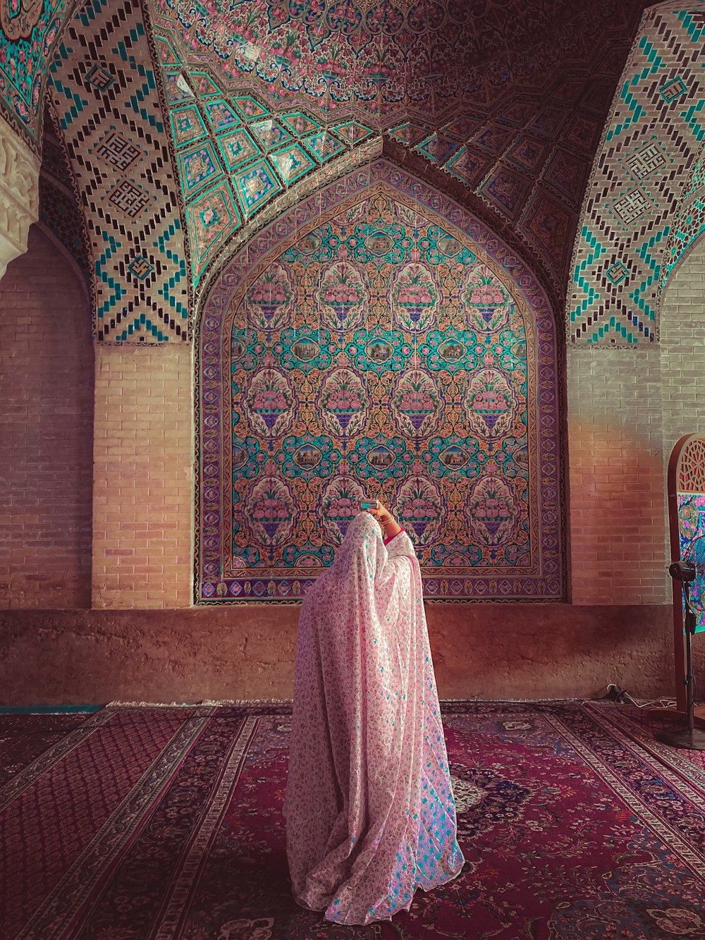 a large colorful room with a large rug and a large window