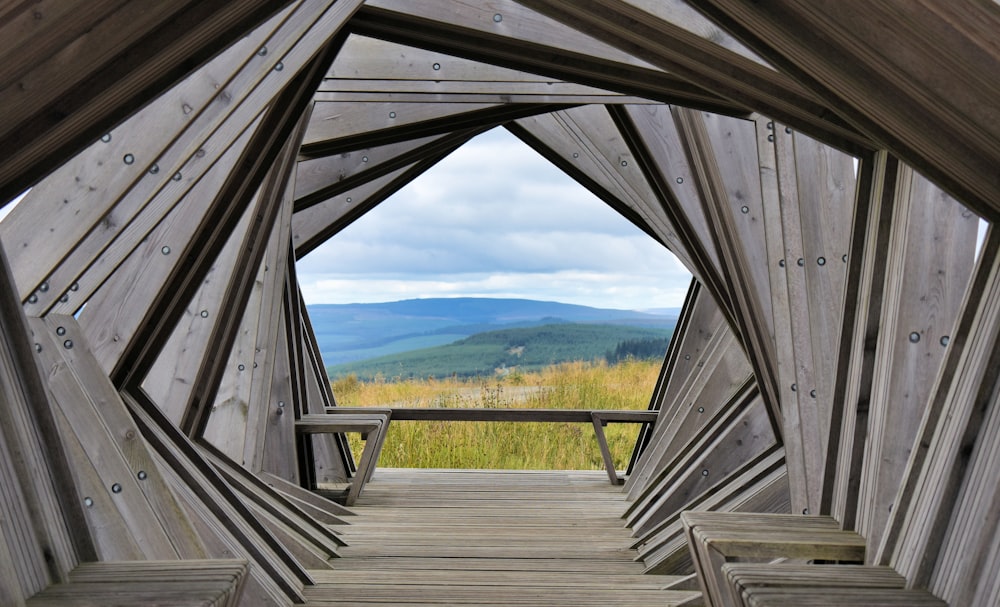 a wooden bridge with a view of a valley and mountains