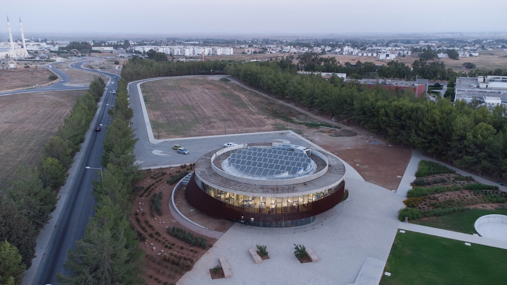 a large stadium with a road and trees around it