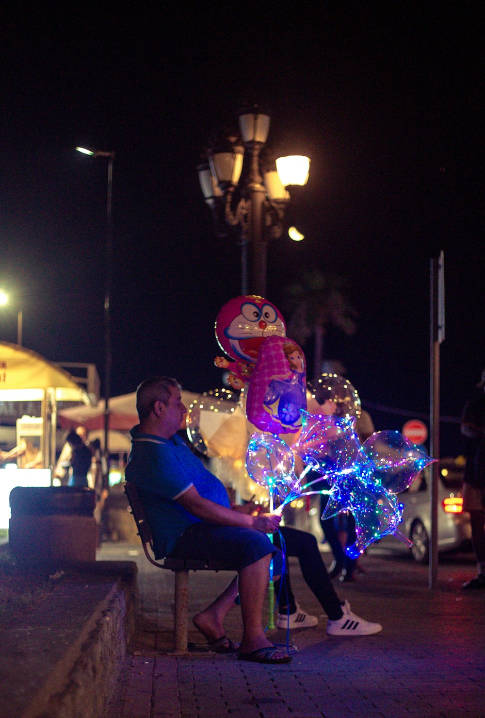 a person sitting on a bench with a large balloon in the background