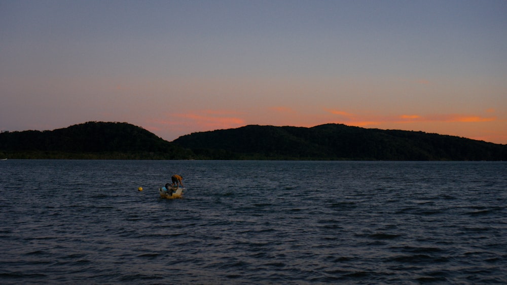 a couple people in a canoe on a lake