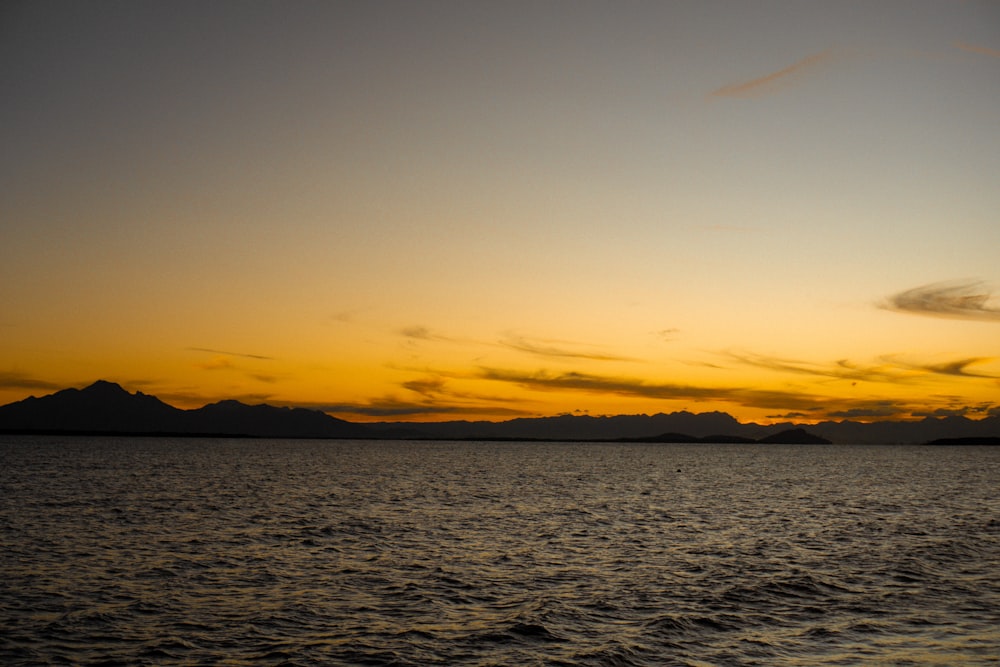 a body of water with mountains in the background