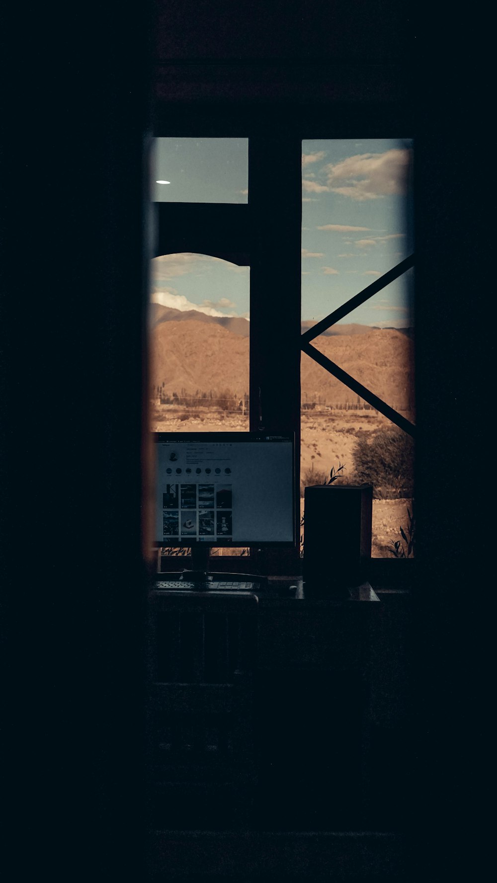 a window with a view of a mountain and a building