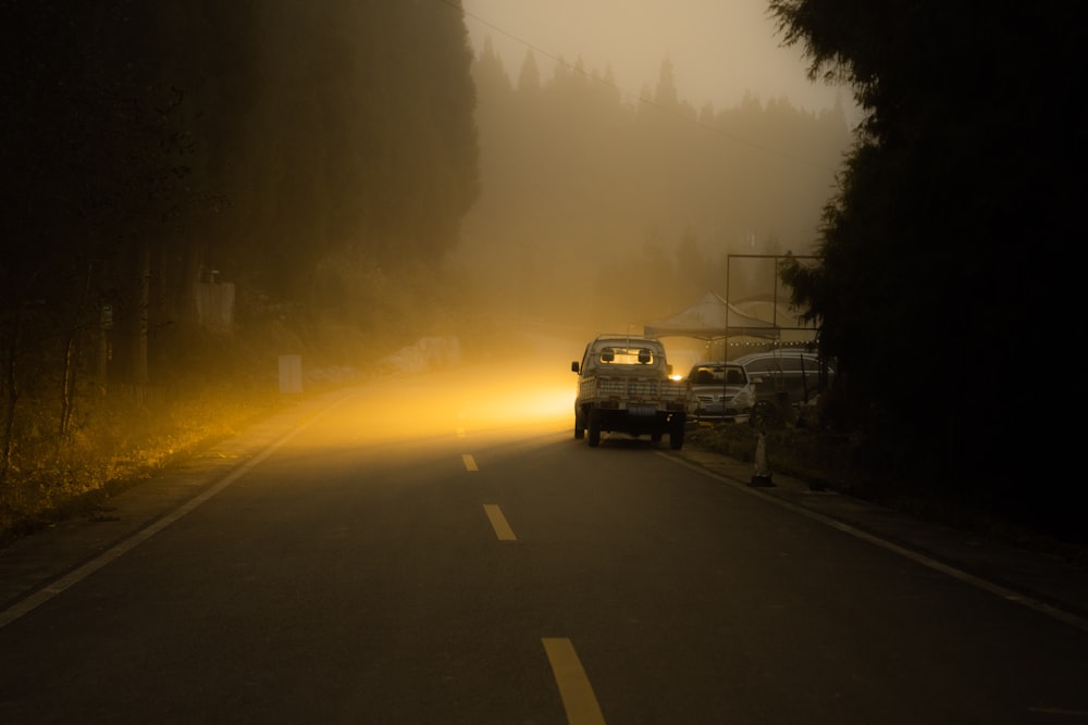 a group of cars on a road with a fire in the distance