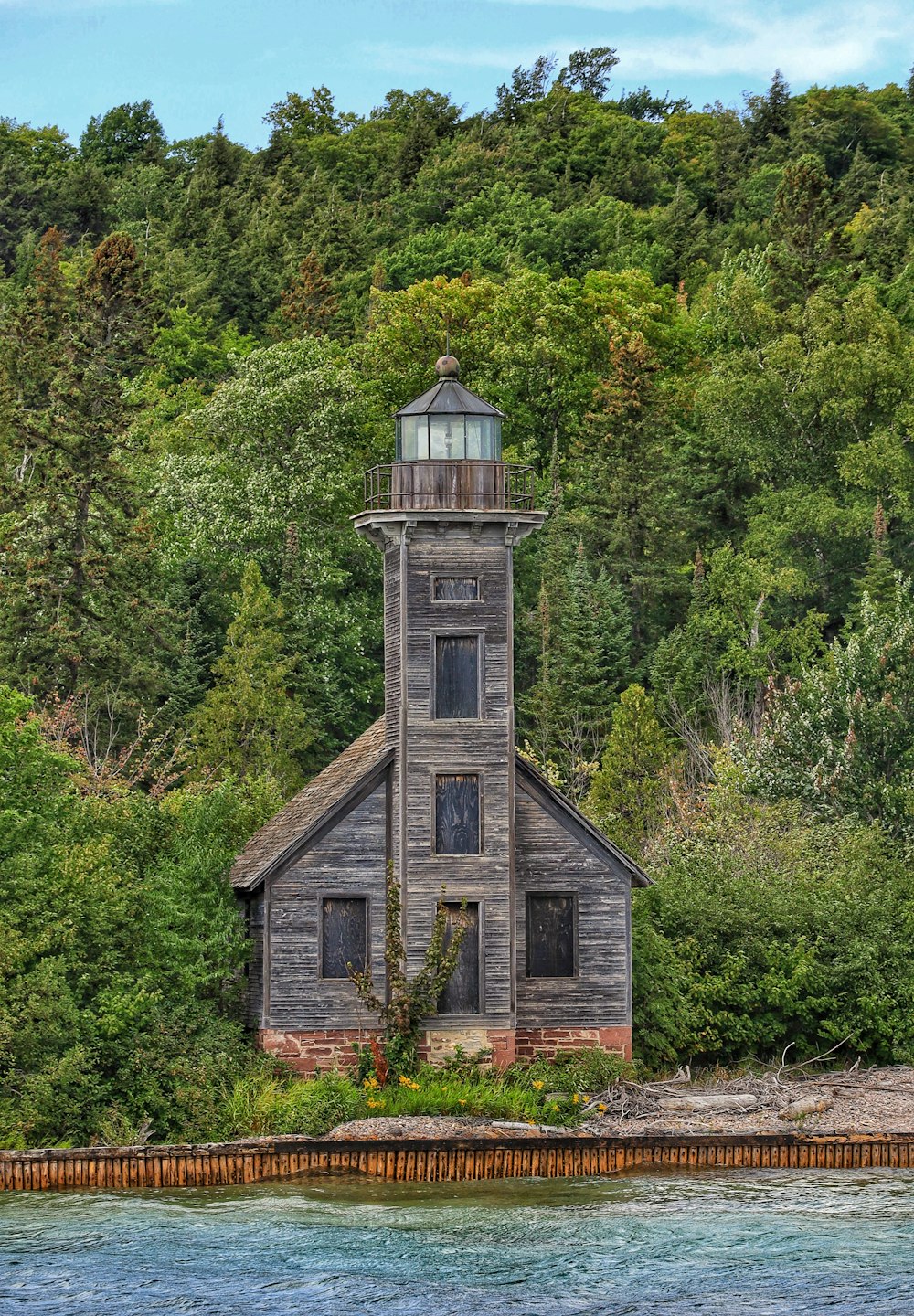 a stone building with a tower surrounded by trees