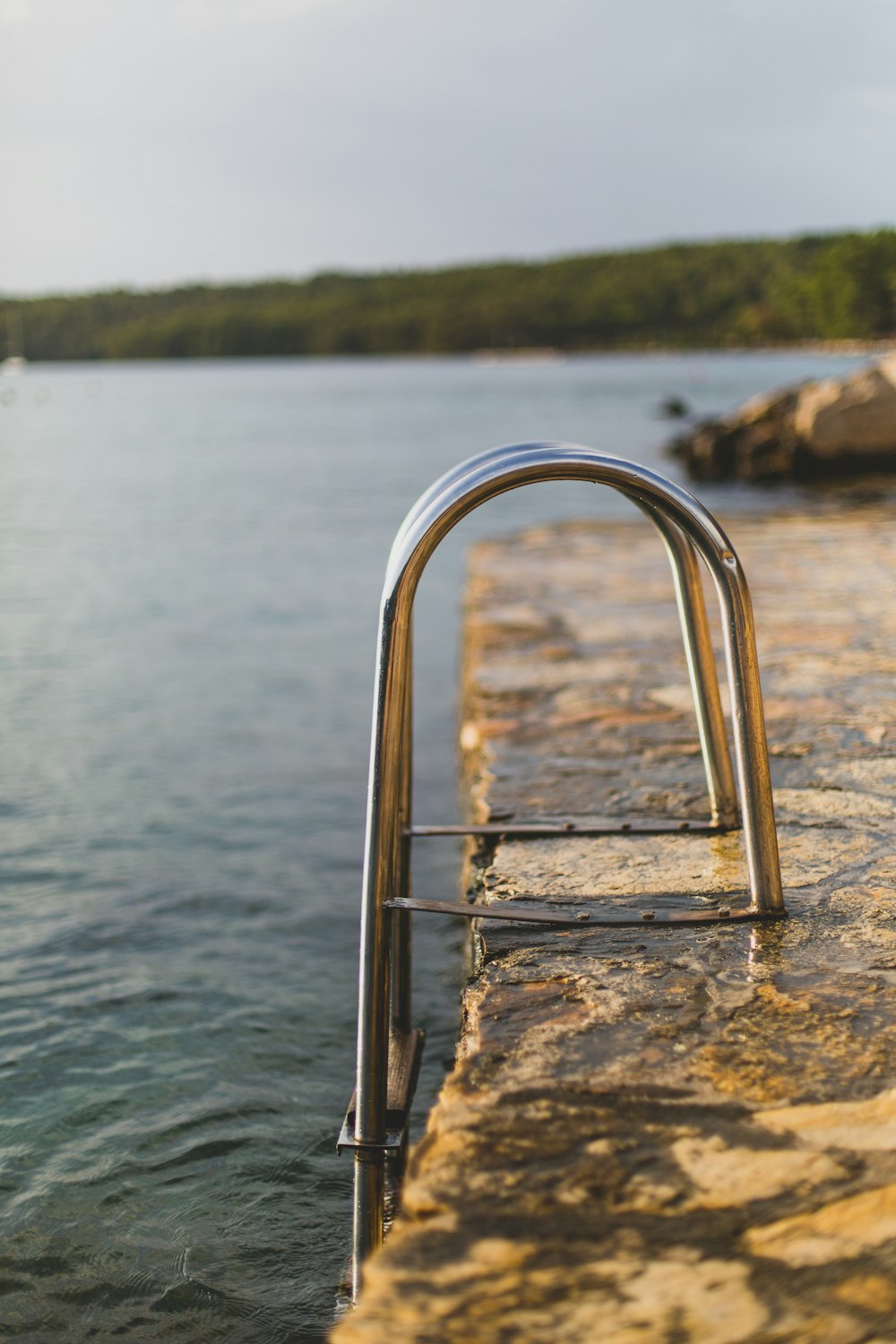 a chair on a rock in the water